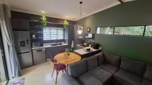 a kitchen with a table and a couch in a room at Pond Cottage in Knysna