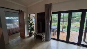 a bedroom with a door open to a patio at Pond Cottage in Knysna