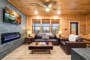a living room with a couch and a tv at Indoor Pool Hot Tub, Pets Welcome, Arcade Games - Sleeps 14 in Pigeon Forge +38 photos