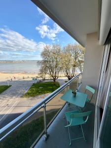 a balcony with a table and chairs and a view of the beach at Apartment with exceptional views in Saint-Nazaire