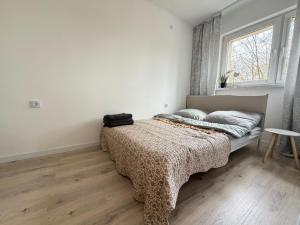 a bedroom with a bed with a blanket and a window at Silesia Park Bytom 24H Park Miejski Centrum in Bytom