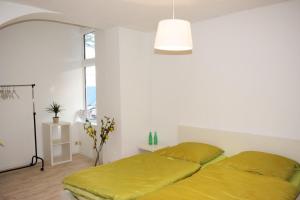 ein Schlafzimmer mit einem Bett mit gelber Bettwäsche und einer Lampe in der Unterkunft Urlaub im Wintergarten Rostock-Lichtenhagen-Dorf in Rostock