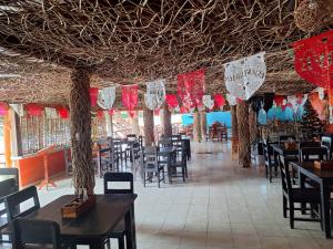 ein Restaurant mit Tischen und Stühlen und rot-weißer Dekoration. in der Unterkunft Restaurante ramirez in Xpujil