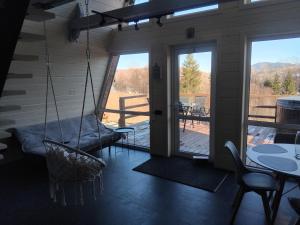 a room with a porch with a swing at A Frame HAPPINESS in Yasinya