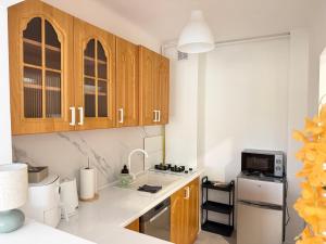 a kitchen with wooden cabinets and a white refrigerator at Silesia Park Bytom 24H Park Miejski Centrum in Bytom +20 photos