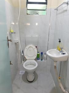 a white bathroom with a toilet and a sink at AA Suites 87 in Nairobi +4 photos