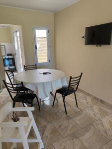 a dining room with a table and chairs and a television at Bungalows Casa Mansa 1 y 2 in Villa Elisa