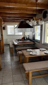 a kitchen with wooden ceilings and tables and a stove at Kuća za odmor IVKOVIĆ in Kupres