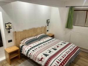 a bedroom with a bed with a comforter on it at La Nicchia in Pieve di Cadore