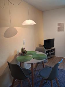 a living room with a table and chairs and a tv at Appartement Ruhe mit zwei Schlafzimmern in Enkirch