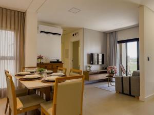 a dining room and living room with a table and chairs at Moov Smart Home – Studios e Apartamentos por Temporada em Cuiabá in Cuiabá