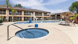 a swimming pool with an umbrella and a building at Tolleson Studio Pool & Gym Access for 2 in Tolleson +20 photos