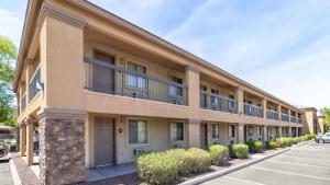 an apartment building with bushes in front of a parking lot at Tolleson Studio Pool & Gym Access for 2 in Tolleson