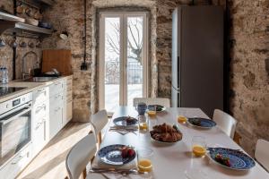 a kitchen with a white table with food on it at Panoramic Stone Retreat - Menaggio by LoveComo in Menaggio