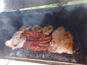 a bunch of different types of meat and vegetables on a grill at Aurora in Santiago del Estero