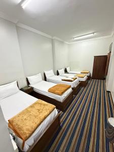 a row of four beds in a room at فندق صفوة الجميزة in An Naqāʼ