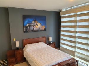 a bedroom with a bed and a picture on the wall at Lujoso Penthouse en la Roma in Mexico City