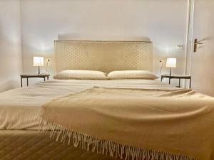 a bedroom with a large bed with two end tables at D'Annunzio in Gardone Riviera