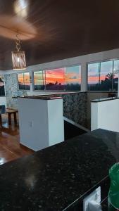 a kitchen with a view of a sunset through the windows at Casa Maragogi 6 Quartos E Piscina in Maragogi