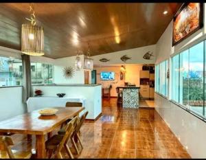 a living room with a wooden table and a dining room at Casa Maragogi 6 Quartos E Piscina in Maragogi