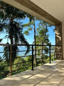 a balcony with a view of the ocean and trees at Pousada Samambaia in Paraty