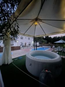 a hot tub under an umbrella on a table at Zuchar in Granada +4 photos
