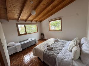 a bedroom with two beds and two windows at Las raíces departamentos in Ushuaia