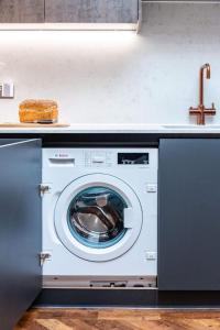 a washing machine in a kitchen with a sink at Luxury Seaside Home, Sleeps 6 in Broadstairs