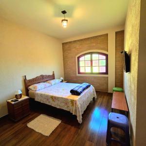 a bedroom with a bed and a window at Pousada Cantinho das Fadas in Conceição da Ibitipoca