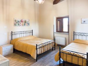 a bedroom with two beds and a window at Casale Saporito in Montopoli in Sabina