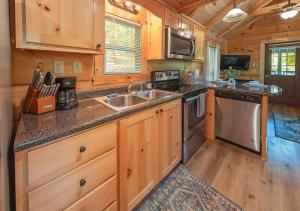 a kitchen with wooden cabinets and stainless steel appliances at Ryon Tiny Home Cabin City-side Rustic Retreat in Chattanooga