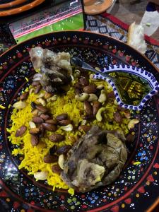 a plate of food with rice and nuts on a table at Dar Sana in Qaşr al Ḩallūf