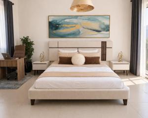 a bedroom with a bed and a painting on the wall at Manzar View - Private Rooftop Dining & Epic Views in As Sīfah +8 photos