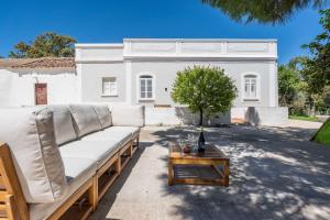 a couch sitting in front of a white building at Spacious & Artistic House with Pool by HostWise in Moncarapacho