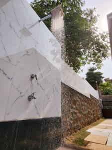 a water fountain with a sink on a wall at Misty Falls Karjat Waterfall view in Jambrung 