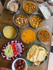 a table topped with bowls of different types of food at Misty Falls Karjat Waterfall view in Jambrung 