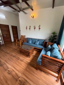 a living room with a blue couch and wooden floors at Misty Falls Karjat Waterfall view in Jambrung 