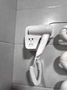 a white phone is hanging on a wall at Shahina in Samarkand