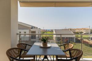 a table and chairs with a view of a balcony at Bianco Mare Studios-Apartments in Kalives Poligirou