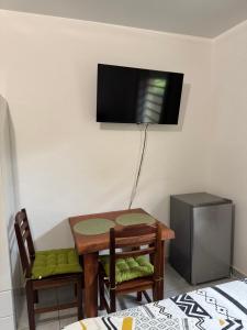 a room with a table and two chairs and a television at Discrétion 17 B in Saint-Laurent du Maroni