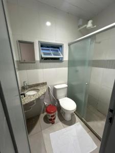 a bathroom with a toilet and a sink and a shower at Pousada do pc in Bom Jesus do Itabapoana +79 photos