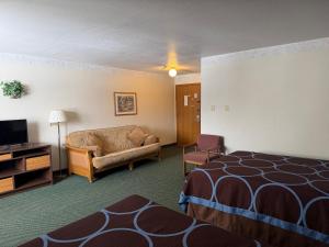 a hotel room with a bed and a couch at Iron Mountain Inn & Suites MI US 2 in Iron Mountain