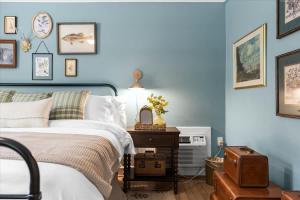 a bedroom with blue walls and a bed and a table at 7- Rock Island Cottage in Lookout Mountain