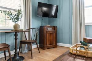 a living room with a table and a tv on the wall at 7- Rock Island Cottage in Lookout Mountain +19 photos