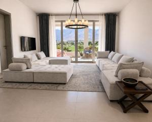 a living room with two couches and a tv at Manzar View - Private Rooftop Dining & Epic Views in As Sīfah
