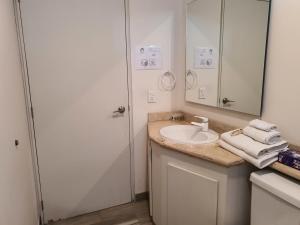 a white bathroom with a sink and a mirror at Lujoso Penthouse en la Roma in Mexico City +19 photos