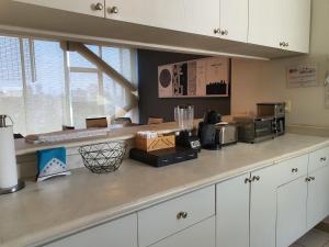 a kitchen with white cabinets and a counter top at Lujoso Penthouse en la Roma in Mexico City