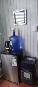a microwave and a blue bucket on top of a refrigerator at Puerto sureño in Puerto Montt