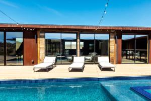 a villa with a swimming pool and a house at Iconic 7,000sf Glass Villa with 2 Pools on 350 Acres in Pioneertown +70 photos