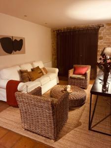 a living room with a couch and wicker chairs at La Posada De Lola in El Molar